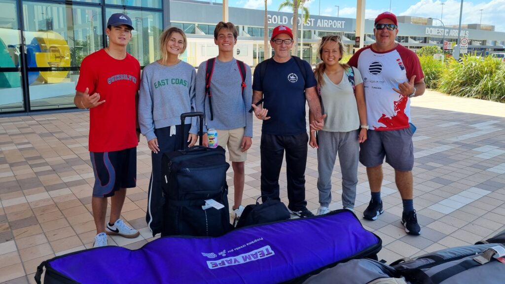 A large group of Peruvian surfers and officials, including Roberto Meza, holding a "Peru Rumbo a Australia" banner for the World Surfing Conservation Conference 2026.