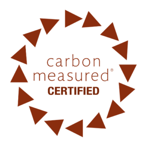 Green Initiative "Carbon Measured Certified" logo featuring a brown text label enclosed within a circular border of 15 brown triangles pointing clockwise.