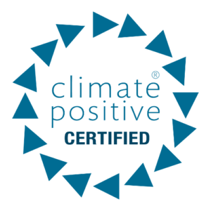 Green Initiative "Climate Positive Certified" logo featuring a teal text label enclosed within a circular border of 15 teal triangles pointing clockwise.
