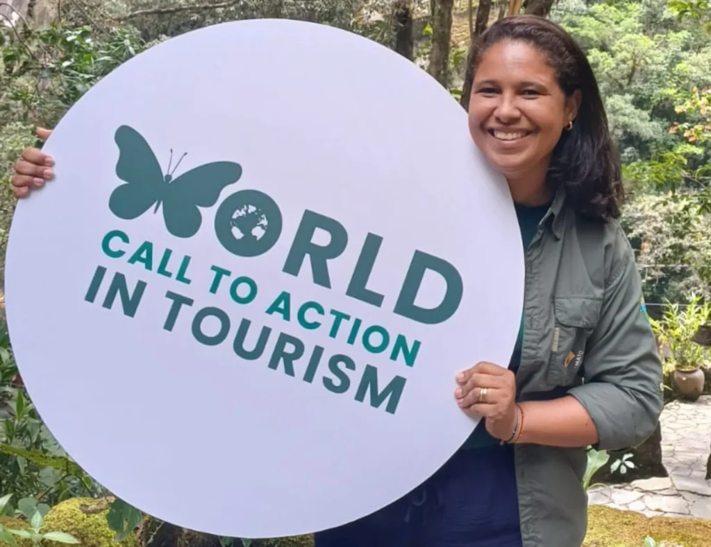 Flavia Neri holding a World Call to Action in Tourism sign for World Environment Day